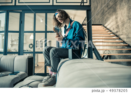 Inspired long-haired guitarist being concentrated on performing 49378205