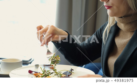 unrecognizable woman eating salad sitting in cafe unrecognizable woman eating salad sitting in cafe 49381975