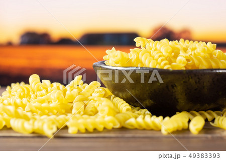 Raw italian torti pasta with autumn field behind Raw italian torti pasta with autumn field behind 49383393