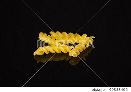 Raw italian torti pasta isolated on black glass Raw italian torti pasta isolated on black glass 49383406