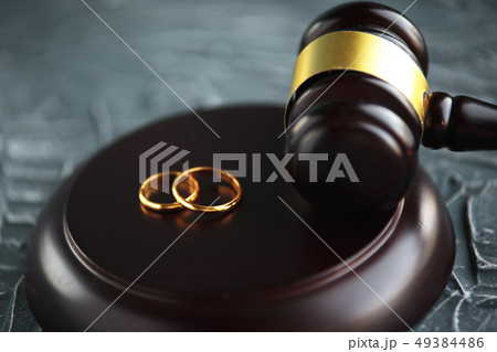 Two broken golden wedding rings divorce decree document. Divorce and separation concept Two broken golden wedding rings divorce decree document. Divorce and separation concept 49384486