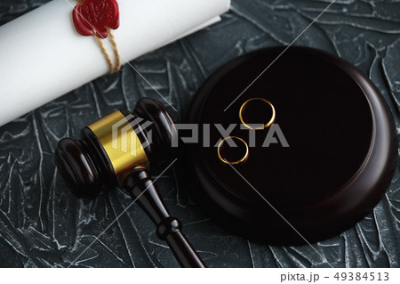 Two broken golden wedding rings divorce decree document. Divorce and separation concept 49384513