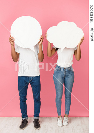 Speech bubbles. Couple holding empty boards, closing their faces Speech bubbles. Couple holding empty boards, closing their faces 49385076