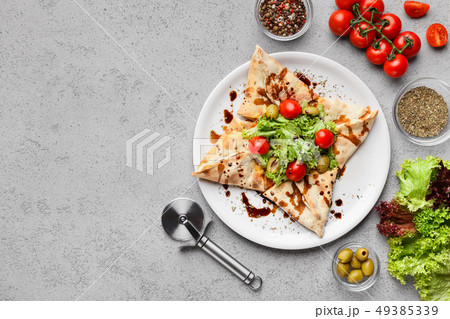 Star shaped pizza decorated with lettuce and tomatoes 49385339