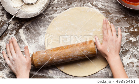 Woman preparing dough for pizza on table, top view Woman preparing dough for pizza on table, top view 49385461