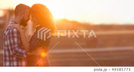 Romantic couple touching foreheads against city sunset 49385773