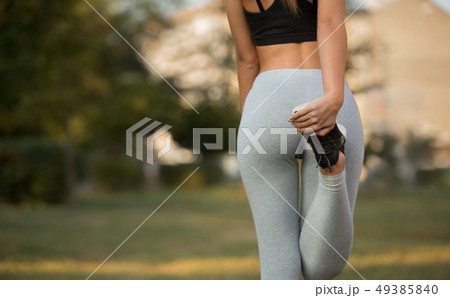 Fitness woman runner stretching legs before run Fitness woman runner stretching legs before run 49385840