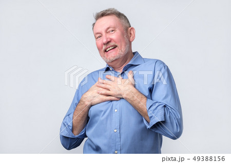Man smiles happily, keeps hands on chest 49388156