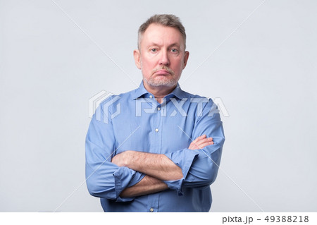 Serious senior man in blue shirt with folded arms Serious senior man in blue shirt with folded arms 49388218