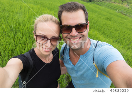 Beautiful love couple having fun taking selfie at beautiful Jatiluwih rice terrace plantations on Beautiful love couple having fun taking selfie at beautiful Jatiluwih rice terrace plantations on 49389039