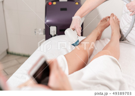 Laser epilation and cosmetology. Hair removal on ladies legs. at cosmetic beauty spa clinic 49389703