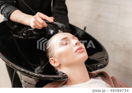beautiful girl washes her hair before a haircut in a beauty salon. hair washing at a hairdressing beautiful girl washes her hair before a haircut in a beauty salon. hair washing at a hairdressing 49389734