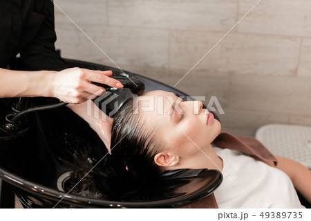 beautiful girl washes her hair before a haircut in a beauty salon. hair washing at a hairdressing 49389735