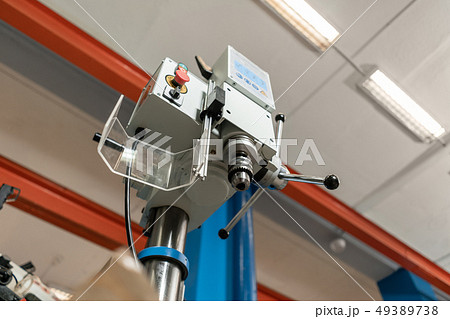 Drilling machine. New Industrial Iron drill in workshop interior. Tool store or exposition stand. Drilling machine. New Industrial Iron drill in workshop interior. Tool store or exposition stand. 49389738