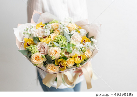 beautiful fresh cut bouquet of mixed flowers in woman hand. the work of the florist at a flower shop 49390198
