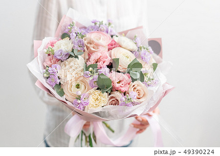 beautiful fresh cut bouquet of mixed flowers in woman hand. the work of the florist at a flower shop 49390224