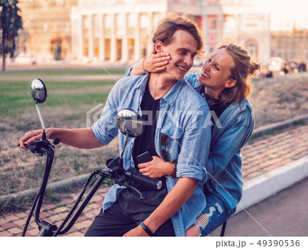 Lovely young couple driving electric bike during summer 49390536