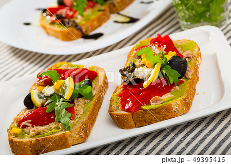 Sandwich with canned tuna, guacamole, olives, arugula and Feta cheese is tasty dish Sandwich with canned tuna, guacamole, olives, arugula and Feta cheese is tasty dish 49395416