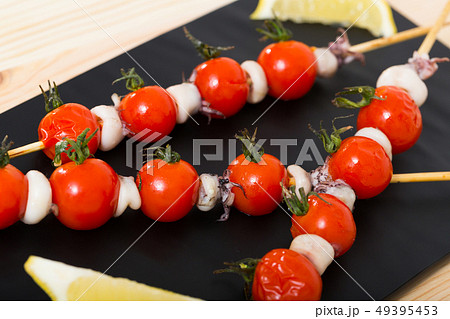 Baked mini calamari and cherry tomatoes on skewers 49395453