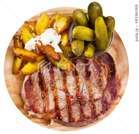 Appetizing beef entrecote with boiled potatoes and pickled cucumbers Appetizing beef entrecote with boiled potatoes and pickled cucumbers 49396369