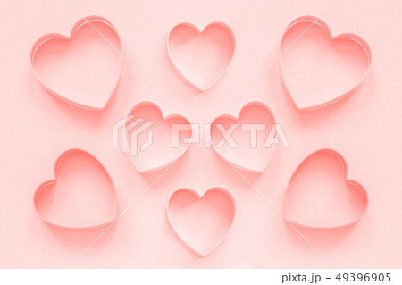 Pink cutters cookies in heart shape on pastel pink Pink cutters cookies in heart shape on pastel pink 49396905