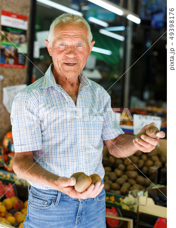 Elderly man looking for fruits in market Elderly man looking for fruits in market 49398176