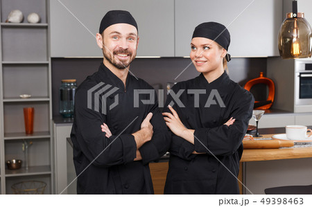 Smiling chefs in black uniform Smiling chefs in black uniform 49398463