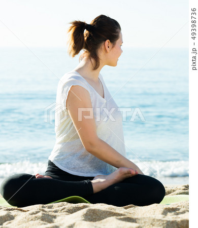 Adult woman in white T-shirt is practicing stretching 49398736