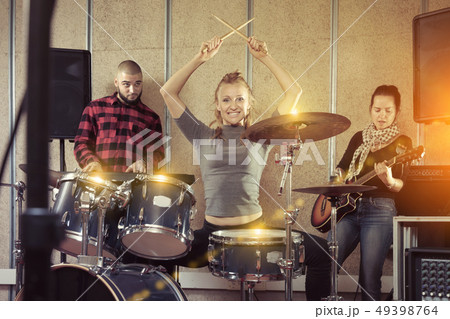 Music band with glad girl drummer rehearsing Music band with glad girl drummer rehearsing 49398764