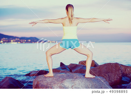 woman in sportwear doing exercises at sunset sea shore woman in sportwear doing exercises at sunset sea shore 49398893