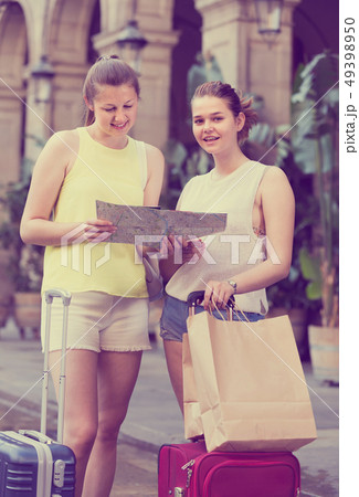 women friends having map and searching tourist route in the city 49398950