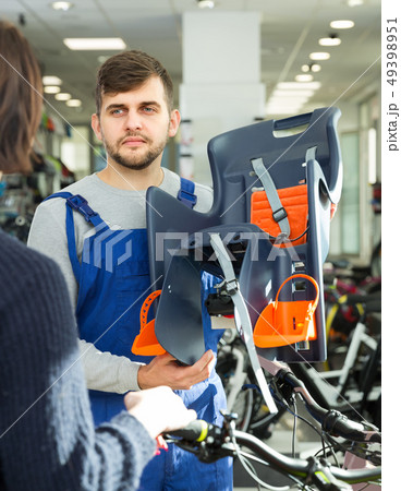 Adult seller demonstrating bicycle sit for child 49398951