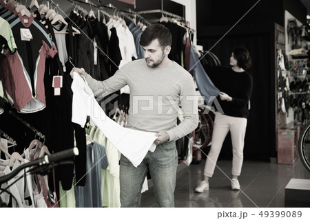 Couple choosing sport shirt in bicycle shop 49399089