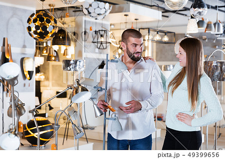 family touching floor lamp in the furniture store family touching floor lamp in the furniture store 49399656