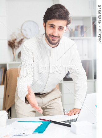 Manager offering to shake hand at office Manager offering to shake hand at office 49399820