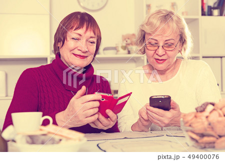 pensioners females holding mobile phones 49400076