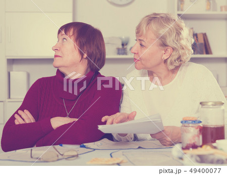 Elderly woman with papers calming female 49400077