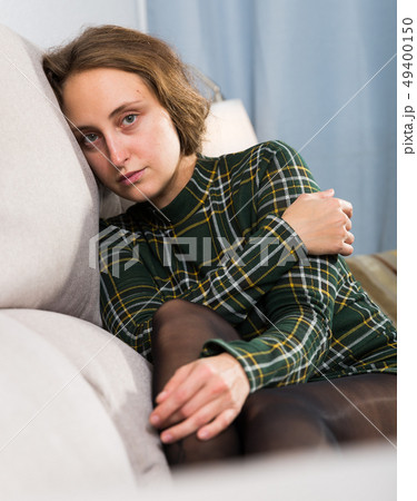 Portrait of sorrowful woman sitting at home Portrait of sorrowful woman sitting at home 49400150