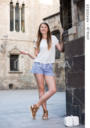 Romantic girl leaning against stone wall Romantic girl leaning against stone wall 49400819