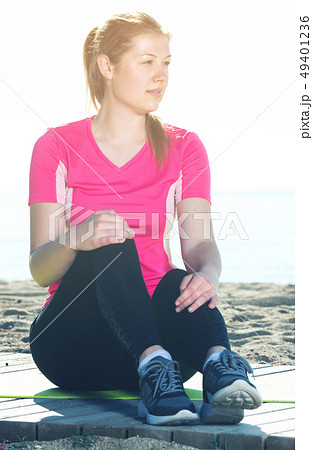 Woman resting after training on beach Woman resting after training on beach 49401236