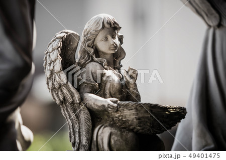 Statue of an angel holding basket in the garden Statue of an angel holding basket in the garden 49401475