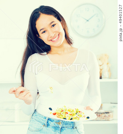 Smiling young girl eating tasty salad Smiling young girl eating tasty salad 49401527