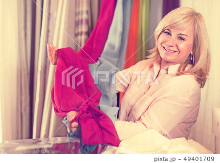 Mature woman customer choosing color curtains Mature woman customer choosing color curtains 49401709