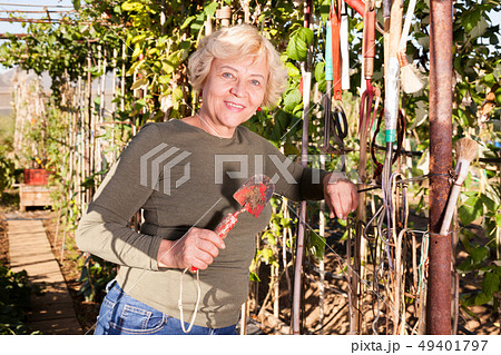 Woman holding garden tools Woman holding garden tools 49401797