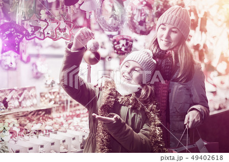 Young girl and her mother are choosing decorations for Christmas 49402618