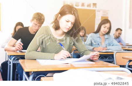 Girl is writing test and answer about task 49402845