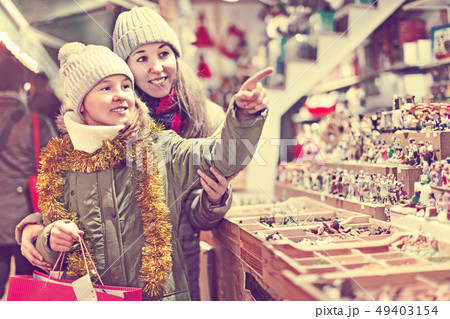 Girl with woman choosing Christmas gifts for family 49403154