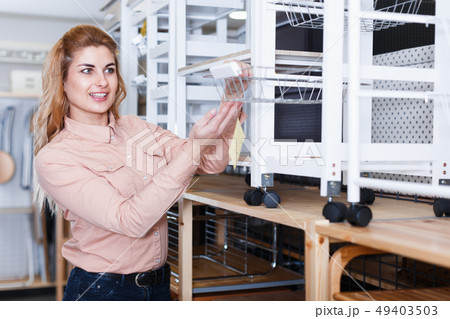 Woman choosing kitchen cabinet in shop 49403503