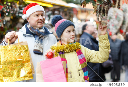 Girl with father choosing Xmas decoration 49403839