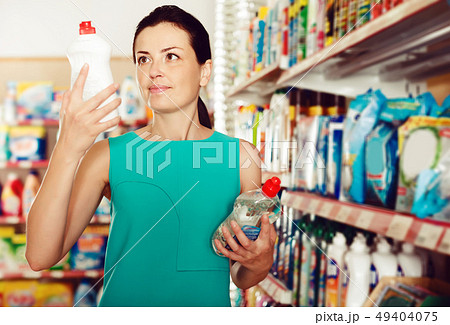Adult woman choosing dishwashing liquid Adult woman choosing dishwashing liquid 49404075